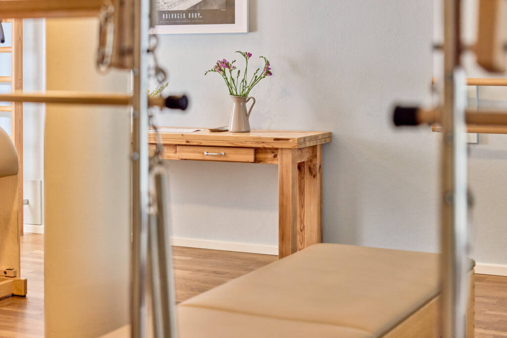 Ansicht Trainingsraum mit Tisch, Vase und pinken Blumen im Makeda Pilates Studio Berlin im Prenzlauer Berg