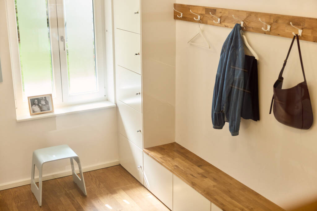 Ansicht Garderobe mit Sitzbank, Fenster, Hocker, Schließfächern und Garderobenhaken im Makeda Pilates Studio Berlin im Prenzlauer Berg