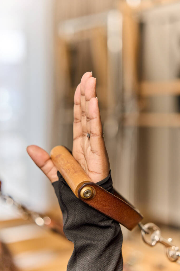 Hand haelt den Buegel einer Reformer Geraetes im Makeda Pilates Studio Berlin