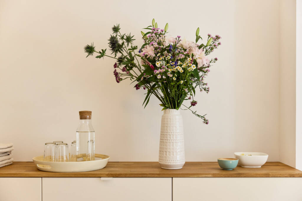Ansicht Sideboard mit Blumenvase und Tablett mit Wasserflasche und Glaesern im Makeda Pilates Studio Berlin im Prenzlauer Berg